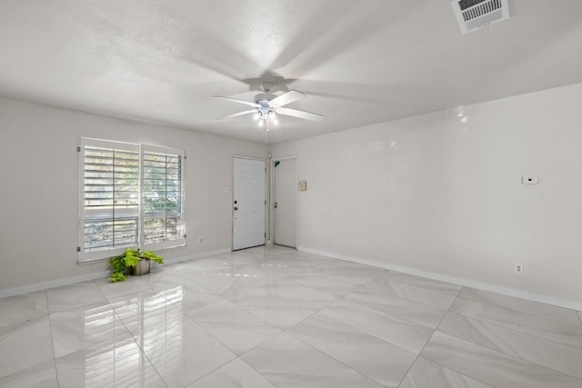 empty room with a textured ceiling and ceiling fan