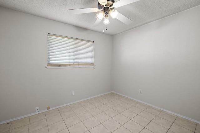 unfurnished room with ceiling fan, light tile patterned floors, and a textured ceiling