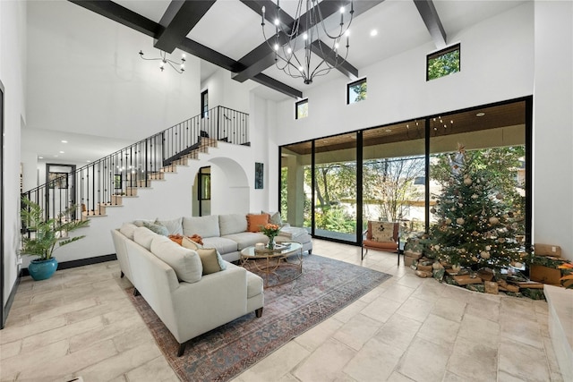 living room with beamed ceiling, a chandelier, and a high ceiling