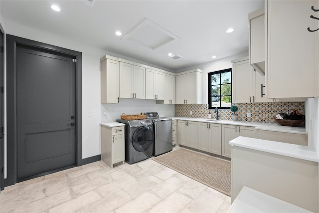 laundry room with cabinets, independent washer and dryer, and sink