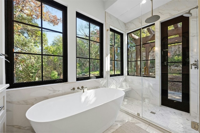 bathroom with a wealth of natural light, tile walls, and independent shower and bath