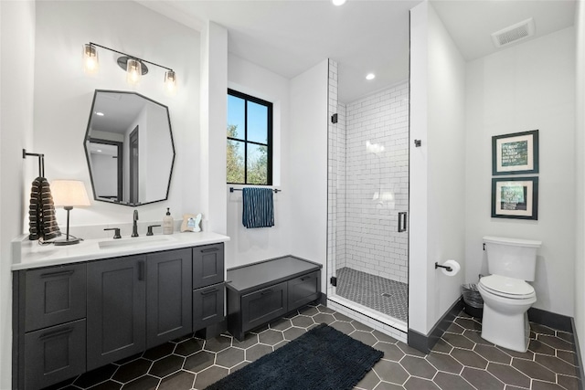 bathroom with vanity, a shower with shower door, and toilet