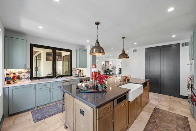 kitchen featuring tasteful backsplash, sink, a center island, and pendant lighting