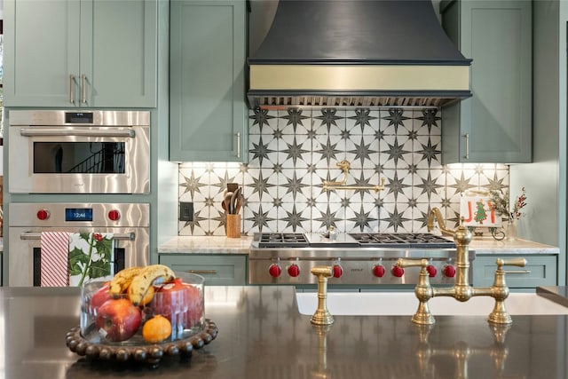 kitchen featuring decorative backsplash, stainless steel appliances, green cabinetry, and custom exhaust hood