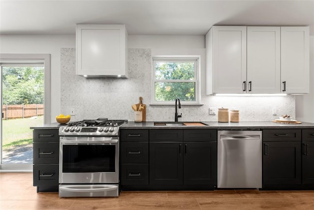 kitchen featuring decorative backsplash, sink, white cabinetry, and stainless steel appliances