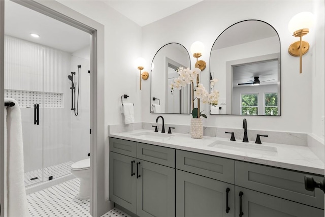 bathroom featuring vanity, a shower with door, toilet, and ceiling fan