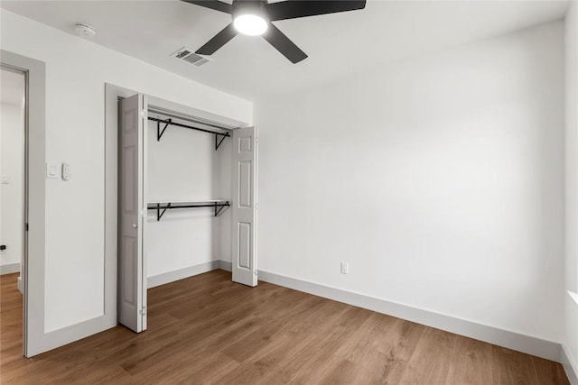 unfurnished bedroom featuring ceiling fan, a closet, and hardwood / wood-style floors