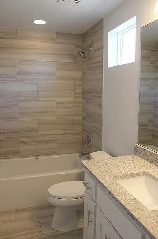 full bathroom featuring vanity, toilet, and tiled shower / bath combo