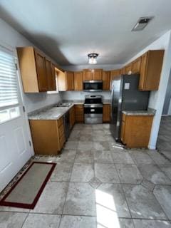5217/5215 Bell Springs Rd, Dripping Springs, TX 78620 - kitchen featuring brown cabinets, light countertops, and appliances with stainless steel finishes