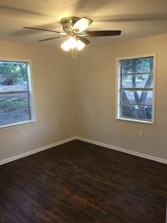 5217/5215 Bell Springs Rd, Dripping Springs, TX 78620 - unfurnished room with dark wood-style floors, ceiling fan, and baseboards