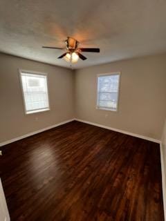 5217/5215 Bell Springs Rd, Dripping Springs, TX 78620 - empty room featuring plenty of natural light, dark wood-style floors, and baseboards