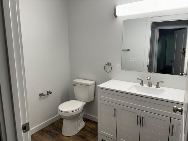 bathroom with wood-type flooring, vanity, and toilet