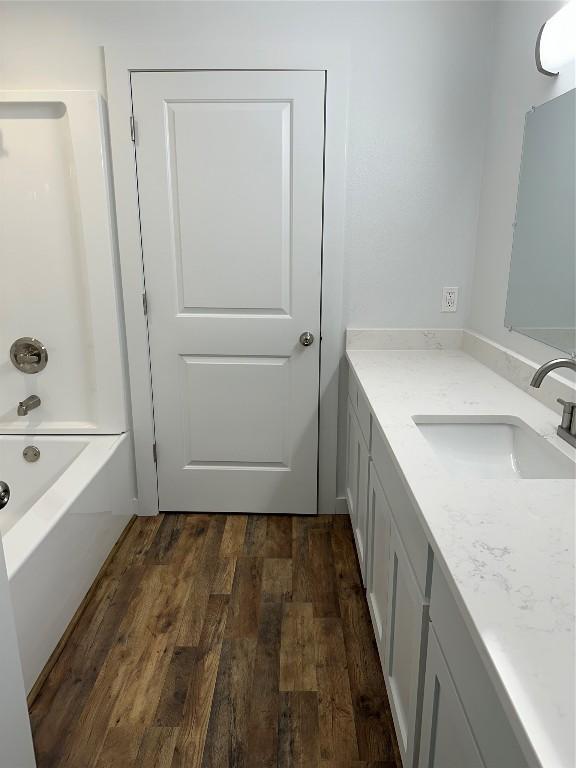 bathroom featuring hardwood / wood-style floors, vanity, and shower / tub combination