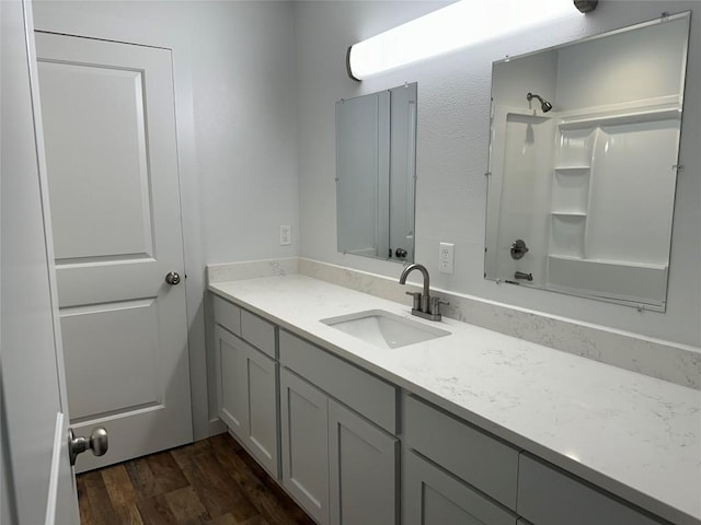 bathroom featuring wood-type flooring, vanity, and tub / shower combination