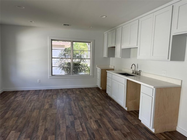 kitchen featuring dark hardwood / wood-style floors, white cabinetry, and sink