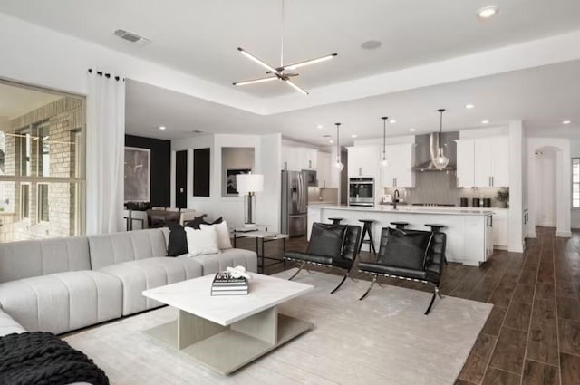 living room featuring sink, a wealth of natural light, and an inviting chandelier