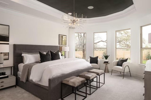 carpeted bedroom with a chandelier and a tray ceiling