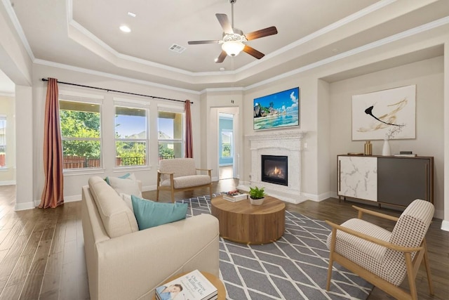 sitting room featuring a tray ceiling, dark hardwood / wood-style floors, crown molding, and ceiling fan