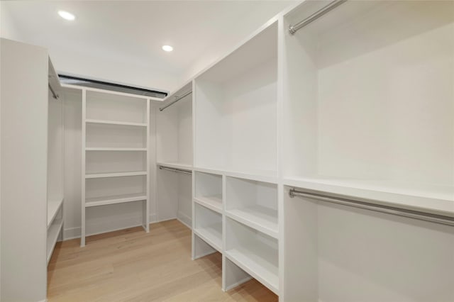 walk in closet with light hardwood / wood-style floors