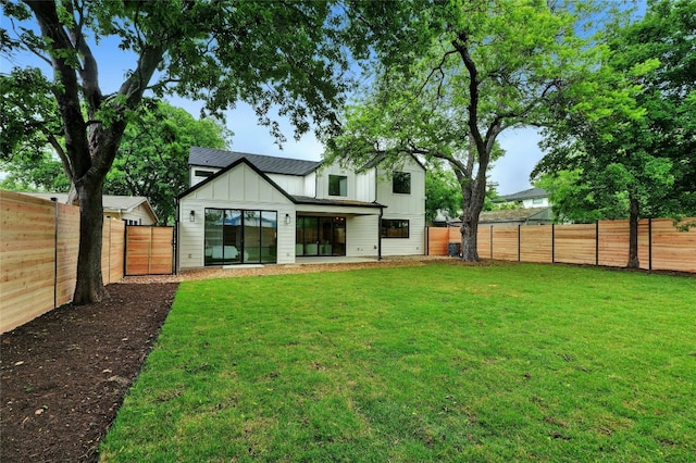 rear view of property with a yard