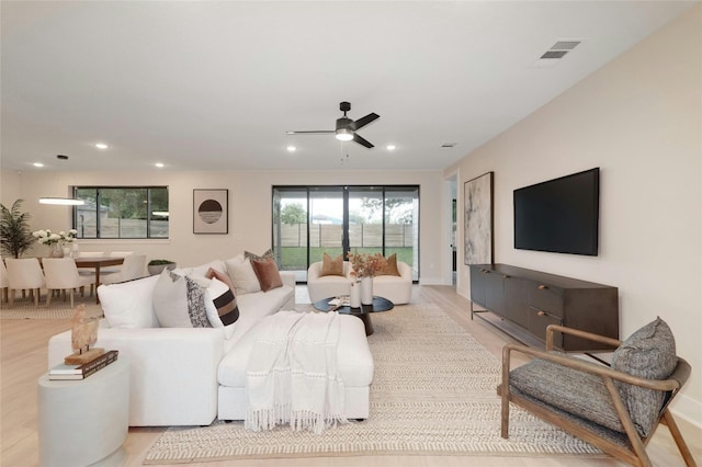 living room with ceiling fan and light hardwood / wood-style floors