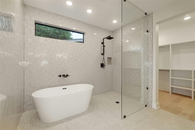 bathroom with tile patterned flooring and shower with separate bathtub