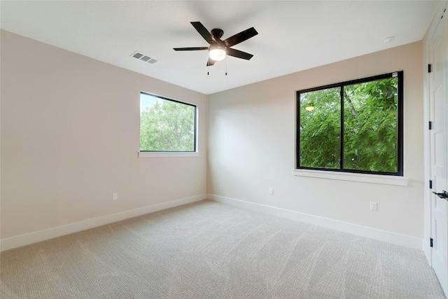 carpeted spare room with ceiling fan