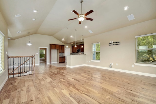 unfurnished living room featuring vaulted ceiling, ceiling fan, and light hardwood / wood-style floors