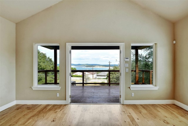 doorway to outside featuring vaulted ceiling, wood finished floors, and baseboards