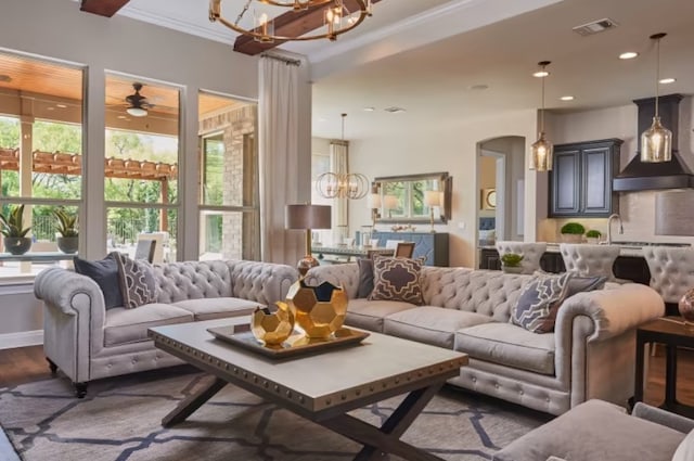 living room featuring sink, dark hardwood / wood-style floors, ceiling fan with notable chandelier, and ornamental molding