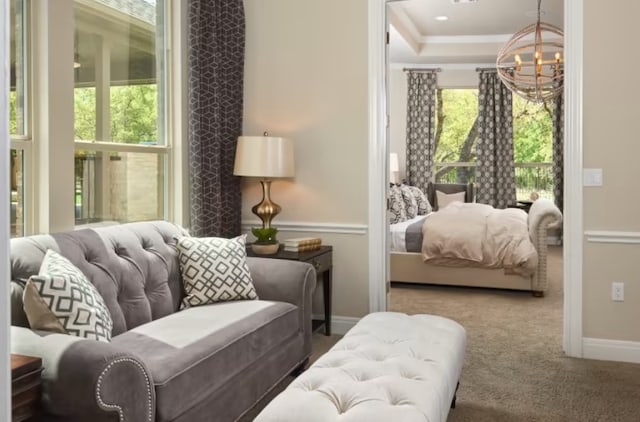 interior space with carpet flooring, a raised ceiling, a chandelier, and ornamental molding