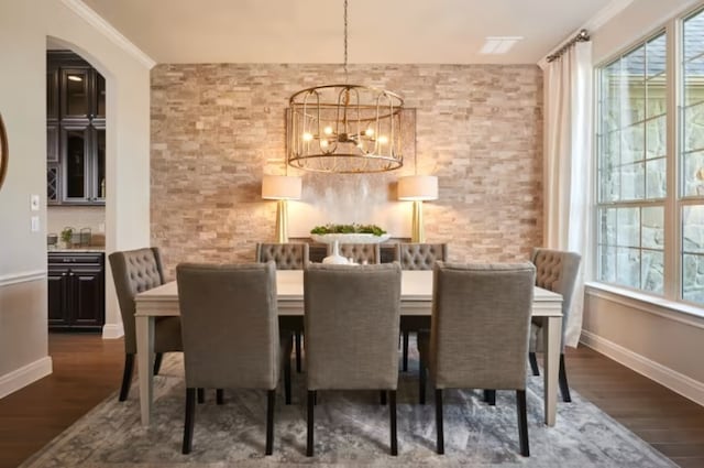 dining area featuring crown molding, a chandelier, and dark hardwood / wood-style floors