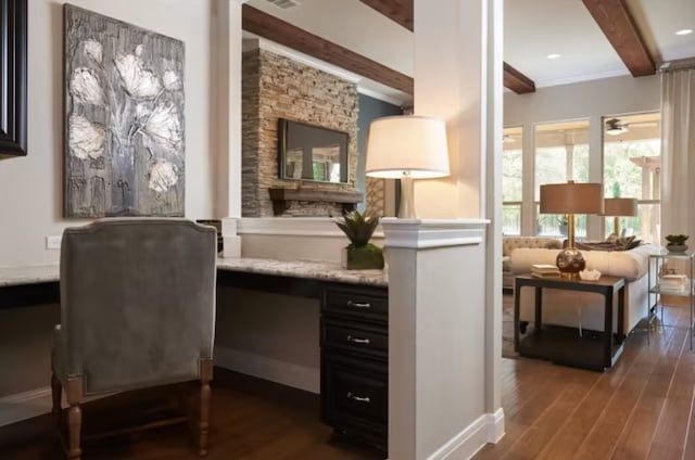 living area with ceiling fan, beam ceiling, dark hardwood / wood-style flooring, and built in desk