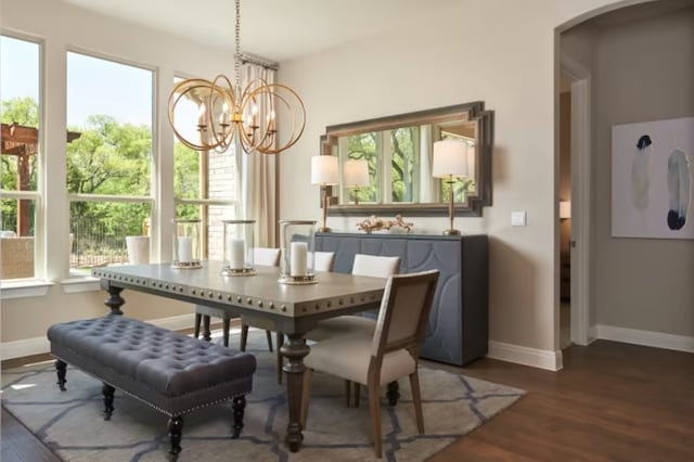 dining space with a notable chandelier and dark hardwood / wood-style flooring