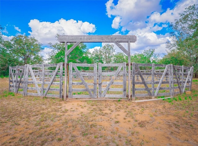 view of gate with a rural view