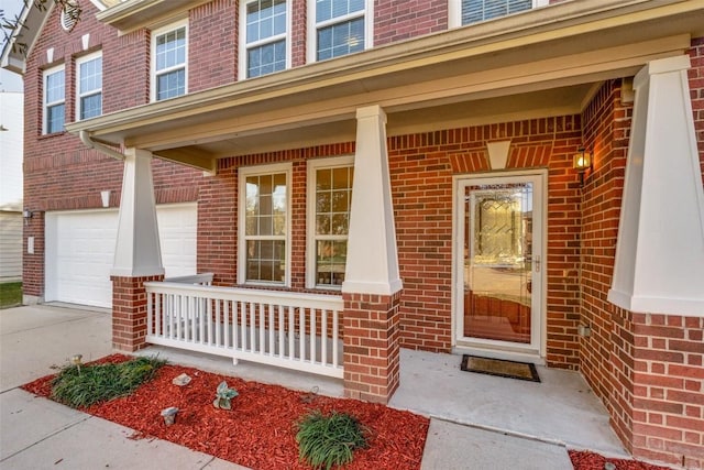 doorway to property featuring covered porch and a garage