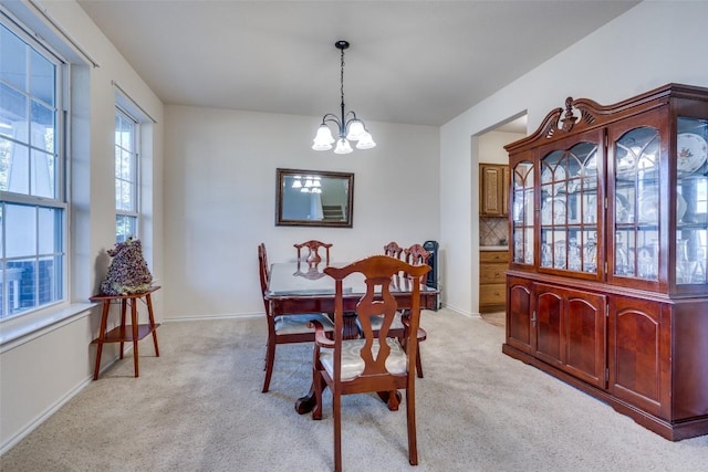 carpeted dining room featuring a chandelier