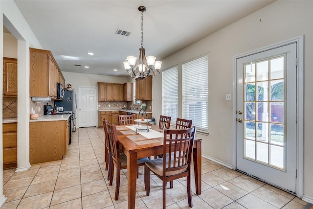 tiled dining area with a chandelier