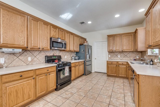 kitchen with decorative backsplash, sink, light tile patterned floors, and stainless steel appliances