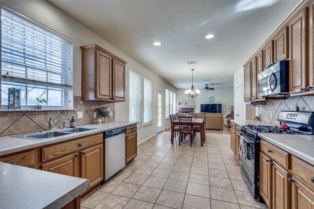 kitchen featuring decorative backsplash, appliances with stainless steel finishes, sink, pendant lighting, and light tile patterned flooring