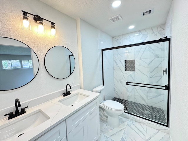 bathroom featuring a shower with shower door, toilet, and vanity