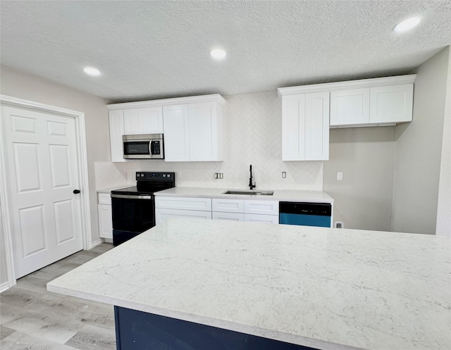 kitchen featuring dishwashing machine, white cabinetry, sink, light wood-type flooring, and electric range