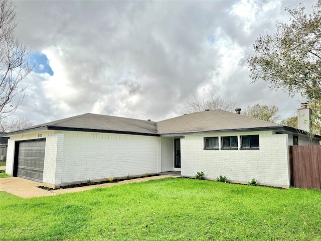 single story home with a garage and a front lawn