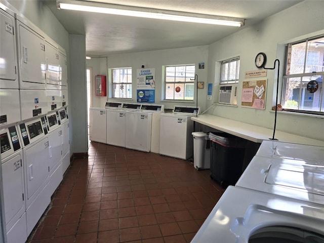 washroom with washing machine and dryer, stacked washer / drying machine, and dark tile patterned flooring