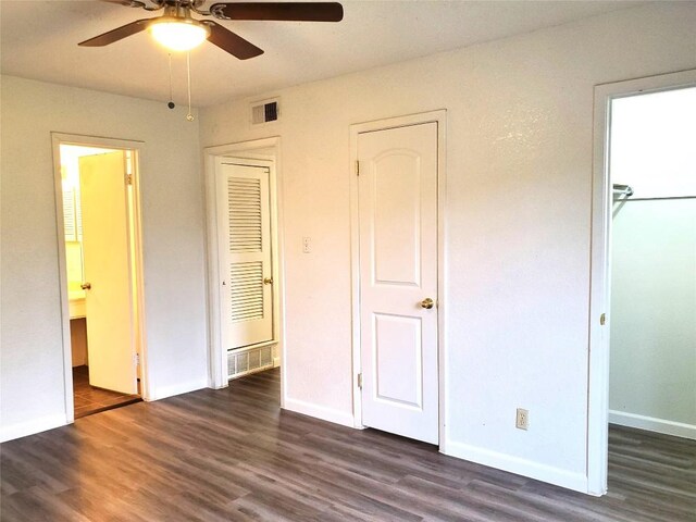 unfurnished bedroom featuring ceiling fan, dark hardwood / wood-style floors, and connected bathroom