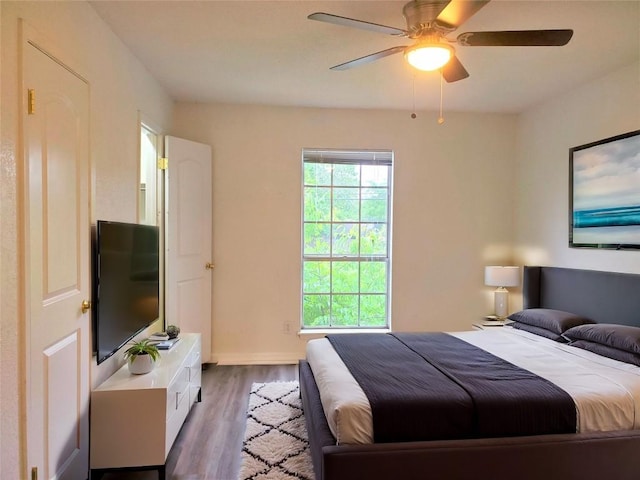 bedroom with dark hardwood / wood-style flooring and ceiling fan