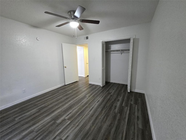 unfurnished bedroom with dark wood-type flooring, ceiling fan, and a closet