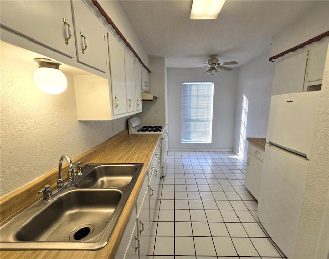 kitchen featuring light tile patterned flooring, white cabinetry, sink, ceiling fan, and white appliances