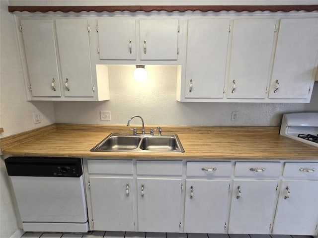 kitchen with white dishwasher, sink, and white cabinetry