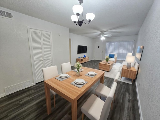 dining space with dark wood-type flooring and ceiling fan with notable chandelier